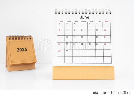 Monthly desk calendar June 2025 year on white table. 121552850