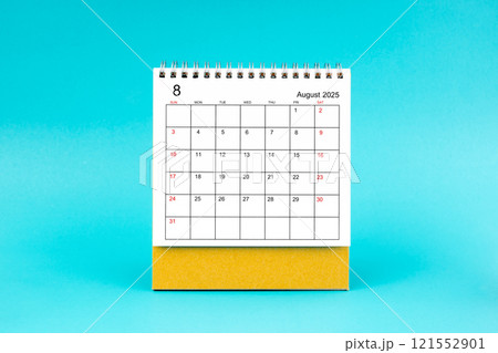 August 2025 desk calendar on blue background. 121552901
