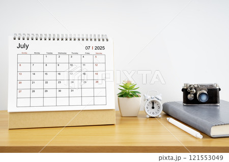 Desktop Calendar for July 2025 year and vintage camera with diary for Planner to plan timetable. 121553049
