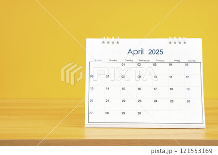 April 2025, Monthly desk calendar for 2025 year on wooden table on yellow background. April 2025, Monthly desk calendar for 2025 year on wooden table on yellow background. 121553169