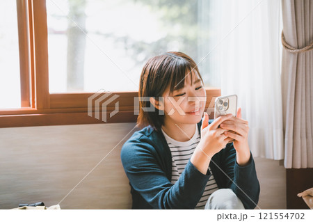 スマホを操作する笑顔の若い女性 121554702