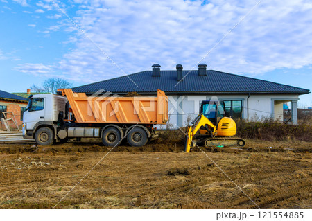 Workers are using dump truck, excavator to prepare land for new house in suburban area. 121554885