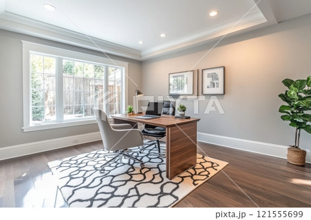 A clean and organized office space with a large window and a potted plant 121555699