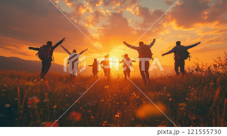 A group of people are running in a field with the sun in the background 121555730