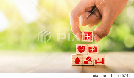Hand arranged wooden blocks with icons of medical health. health insurance for your health concept. Healthcare medical business, medical technology equipment icon. Hand arranged wooden blocks with icons of medical health. health insurance for your health concept. Healthcare medical business, medical technology equipment icon. 121556740