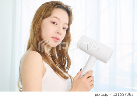 ドライヤーで髪を乾かす女性 121557363