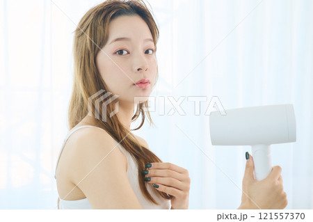 ドライヤーで髪を乾かす女性 121557370