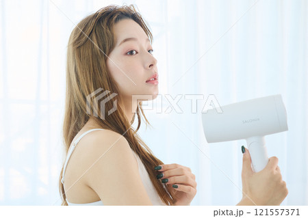 ドライヤーで髪を乾かす女性 121557371