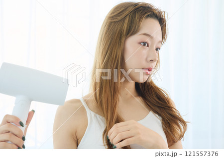 ドライヤーで髪を乾かす女性 121557376