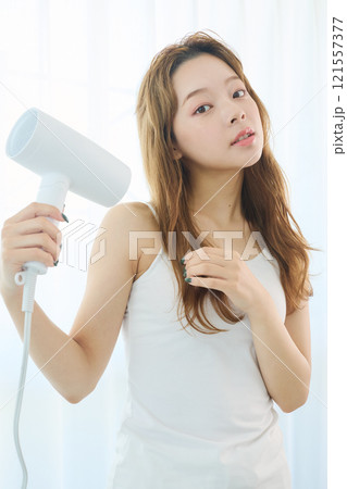 ドライヤーで髪を乾かす女性 121557377