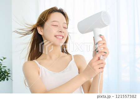 ドライヤーで髪を乾かす女性 121557382