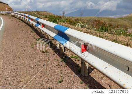 Road safety barriers and winding road in Armenia on a sunny day with clouds Road safety barriers and winding road in Armenia on a sunny day with clouds 121557993