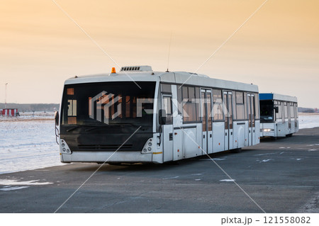 Two empty airport shuttle buses in a cold winter evening 121558082