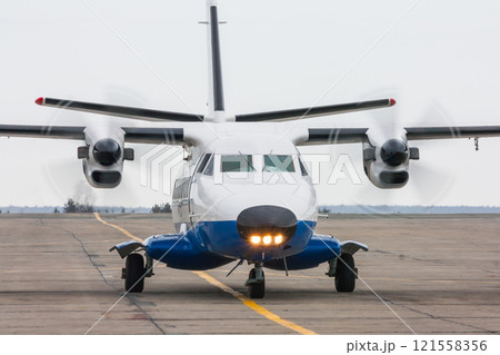 A small regional turboprop airplane at the airport apron 121558356