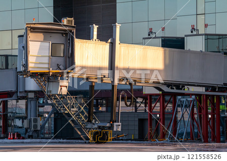 Empty passenger boarding bridge at airport apron Empty passenger boarding bridge at airport apron 121558526