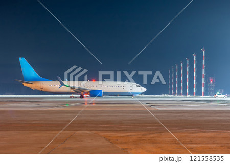 The passenger airliner moves behind the follow-me car at the night ariport apron 121558535