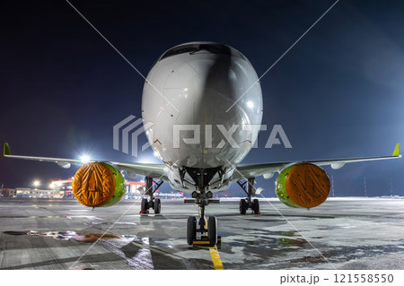 Front view of the modern passenger airliner on the night airport apron 121558550