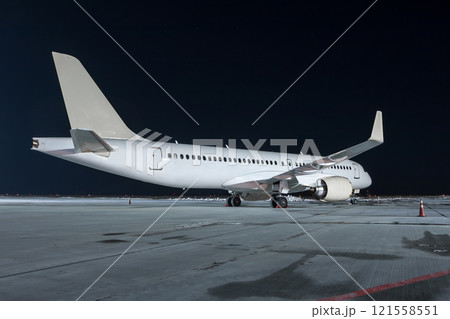 Modern white passenger airplane on the night airport apron 121558551