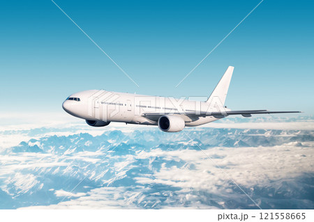 White wide body passenger airliner fly in the air over snow covered mountains White wide body passenger airliner fly in the air over snow covered mountains 121558665