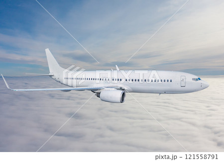 White passenger airplane fly in the air above the clouds 121558791