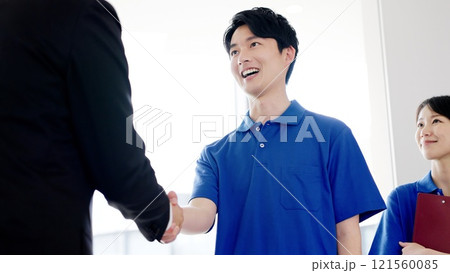 握手をする介護士と福祉用具専門相談員 握手をする介護士と福祉用具専門相談員 121560085