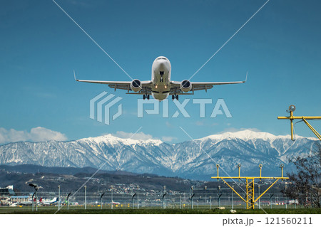 Takeoff of a white passenger aircraft against the backdrop of high picturesque mountains Takeoff of a white passenger aircraft against the backdrop of high picturesque mountains 121560211