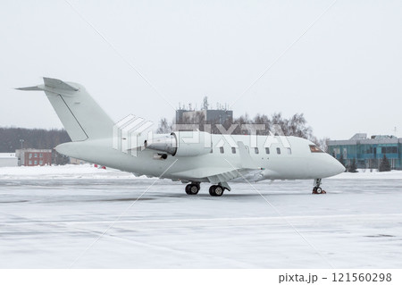 White luxury executive aircraft on the winter airport apron 121560298