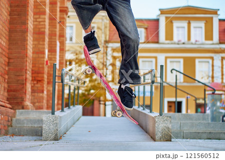 Skateboarder Performing Trick on Urban Street 121560512