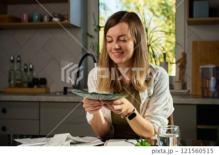 Happy woman counting dollar banknotes at home. Budget planning Happy woman counting dollar banknotes at home. Budget planning 121560515