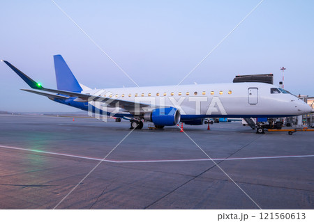 A passenger aircraft parked by the boarding bridge A passenger aircraft parked by the boarding bridge 121560613