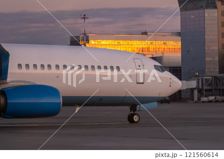 A close-up of the front of a passenger airplane. The aircraft is taxiing at the airport apron near the terminal A close-up of the front of a passenger airplane. The aircraft is taxiing at the airport apron near the terminal 121560614