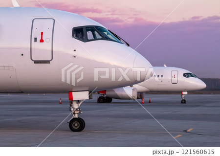 Front parts of modern passenger aircrafts on the morning apron of the airport 121560615