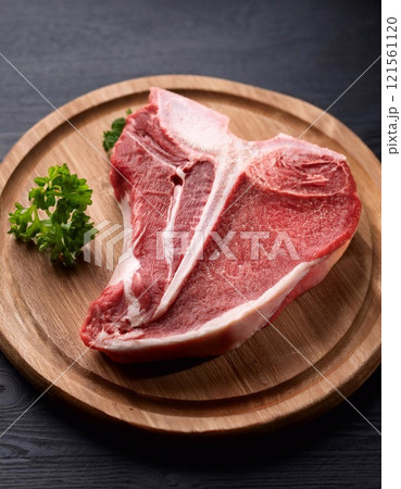 Raw t-bone beef on the wooden plate Raw t-bone beef on the wooden plate 121561120