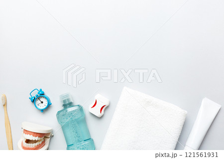 Mouthwash and other oral hygiene products on colored table top view with copy space. Flat lay. Dental hygiene. Oral care products and space for text on light background. concept Mouthwash and other oral hygiene products on colored table top view with copy space. Flat lay. Dental hygiene. Oral care products and space for text on light background. concept 121561931