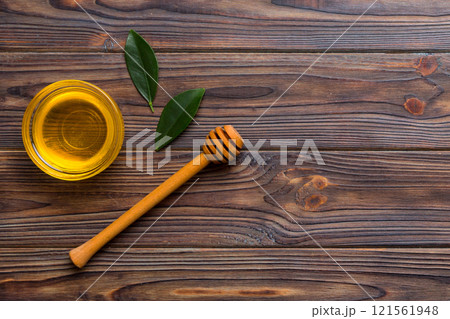 Honey jar with wooden honey dipper on white background top view with copy space. Delicious honey bottle Honey jar with wooden honey dipper on white background top view with copy space. Delicious honey bottle 121561948