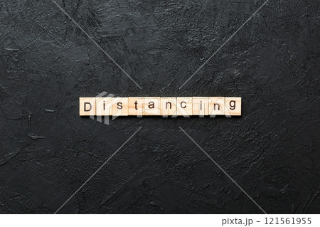 distancing word written on wood block. distancing text on cement table for your desing, concept 121561955