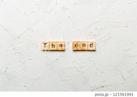 The end word written on wood block. The end text on cement table for your desing, concept 121561991