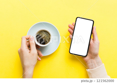 Top view of woman hands holding smart phone with blank copy space screen for your text message or information content. woman hand using phone white screen on top view 121562000