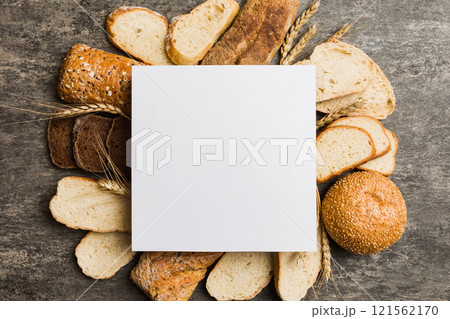 Minimalist paper blank mockup on background of Types of homemade bread. Different kinds of fresh bread as background, top view with space for your text or design 121562170