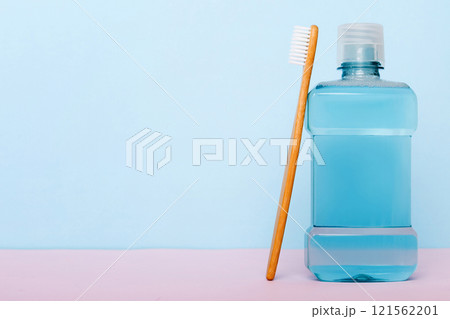 Mouthwash and other oral hygiene products on colored table top view with copy space. Flat lay. Dental hygiene. Oral care products and space for text on light background. concept Mouthwash and other oral hygiene products on colored table top view with copy space. Flat lay. Dental hygiene. Oral care products and space for text on light background. concept 121562201