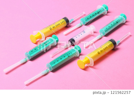 Top view of different syringes at pink background. Medical injection concept with copy space 121562257