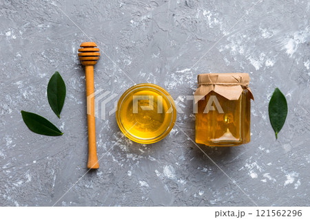 Honey jar with wooden honey dipper on white background top view with copy space. Delicious honey bottle 121562296