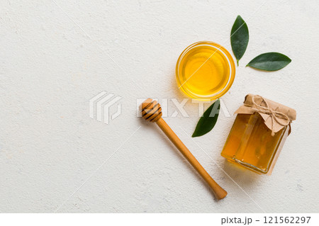 Honey jar with wooden honey dipper on white background top view with copy space. Delicious honey bottle 121562297