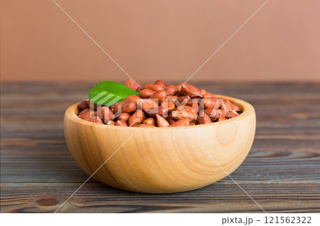 Fresh healthy peanuts in bowl on colored table background. Top view Healthy eating bertholletia concept. Super foods Fresh healthy peanuts in bowl on colored table background. Top view Healthy eating bertholletia concept. Super foods 121562322