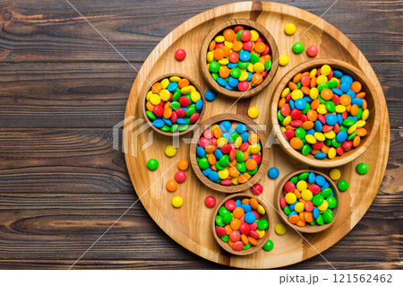 different colored round candy in bowl and jars. Top view of large variety sweets and candies with copy space 121562462