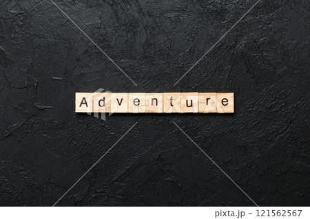 adventure word written on wood block. adventure text on cement table for your desing, concept 121562567