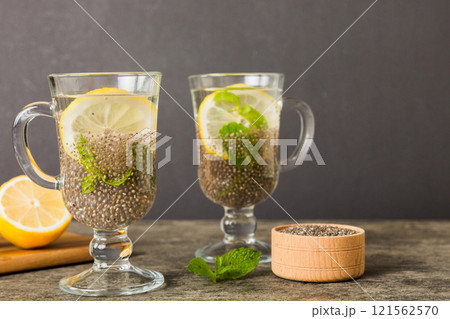 Healthy breakfast or morning with chia seeds lemon and mint on table background, vegetarian food, diet and health concept. Chia pudding with lemon and mint 121562570