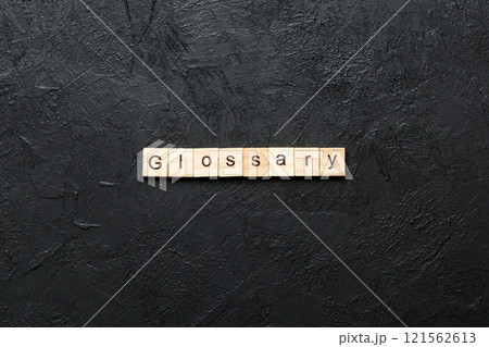 Glossary word written on wood block. Glossary text on cement table for your desing, Top view concept 121562613