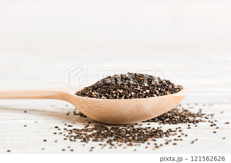 Wooden spoon and chia seeds on colored background, top view. Healthy Salvia hispanica Healthy superfood 121562626