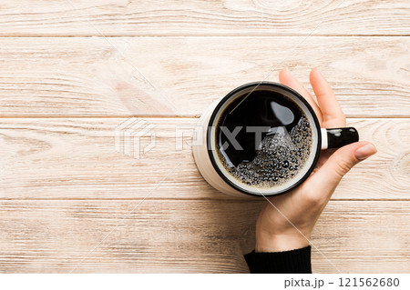 Minimalistic style woman hand holding a cup of coffee on Colored background. Flat lay, top view cappuccino cup. Empty place for text, copy space. Coffee addiction. Top view, flat lay Minimalistic style woman hand holding a cup of coffee on Colored background. Flat lay, top view cappuccino cup. Empty place for text, copy space. Coffee addiction. Top view, flat lay 121562680